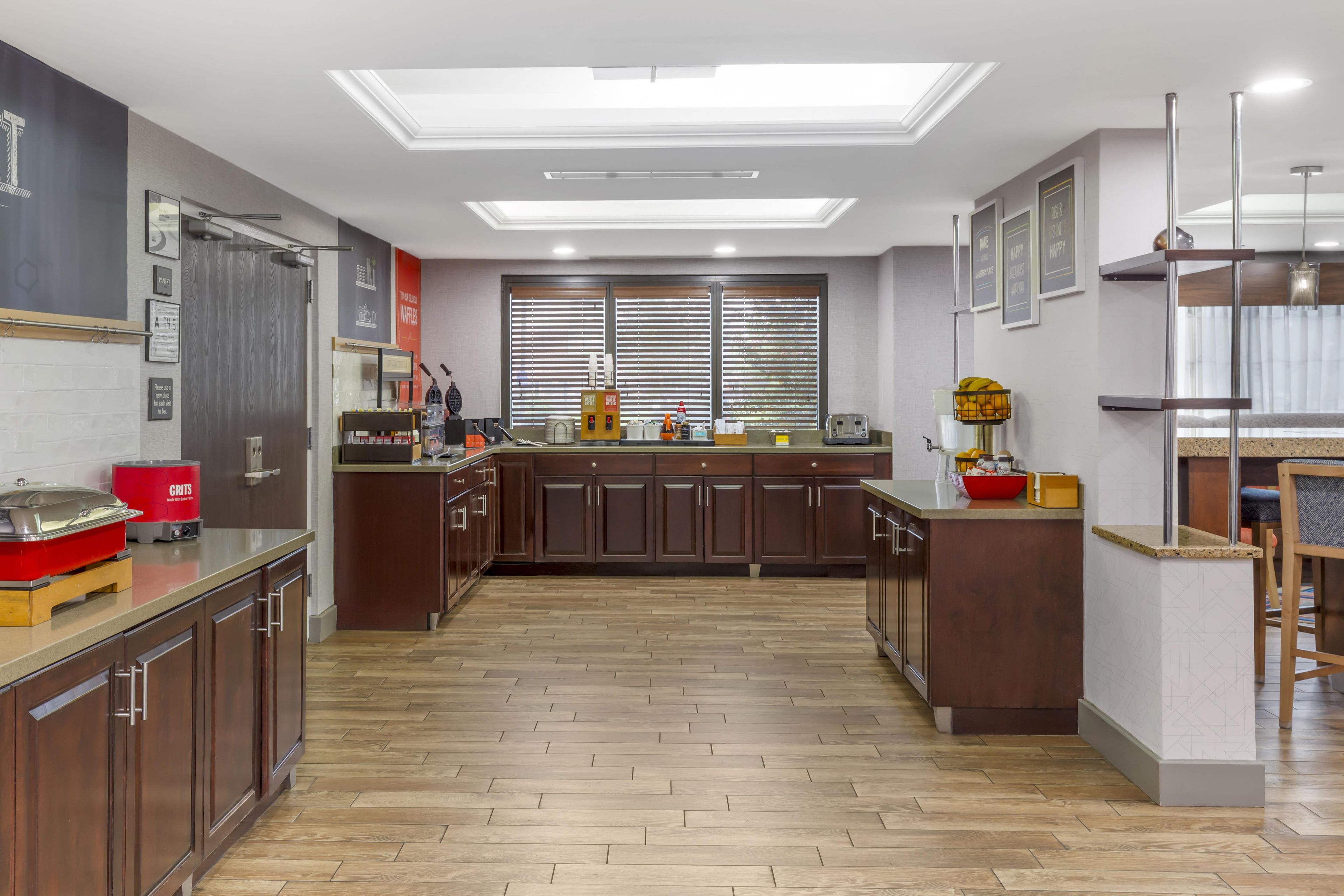 Una cocina moderna con armarios de madera, una isla central y un tragaluz.