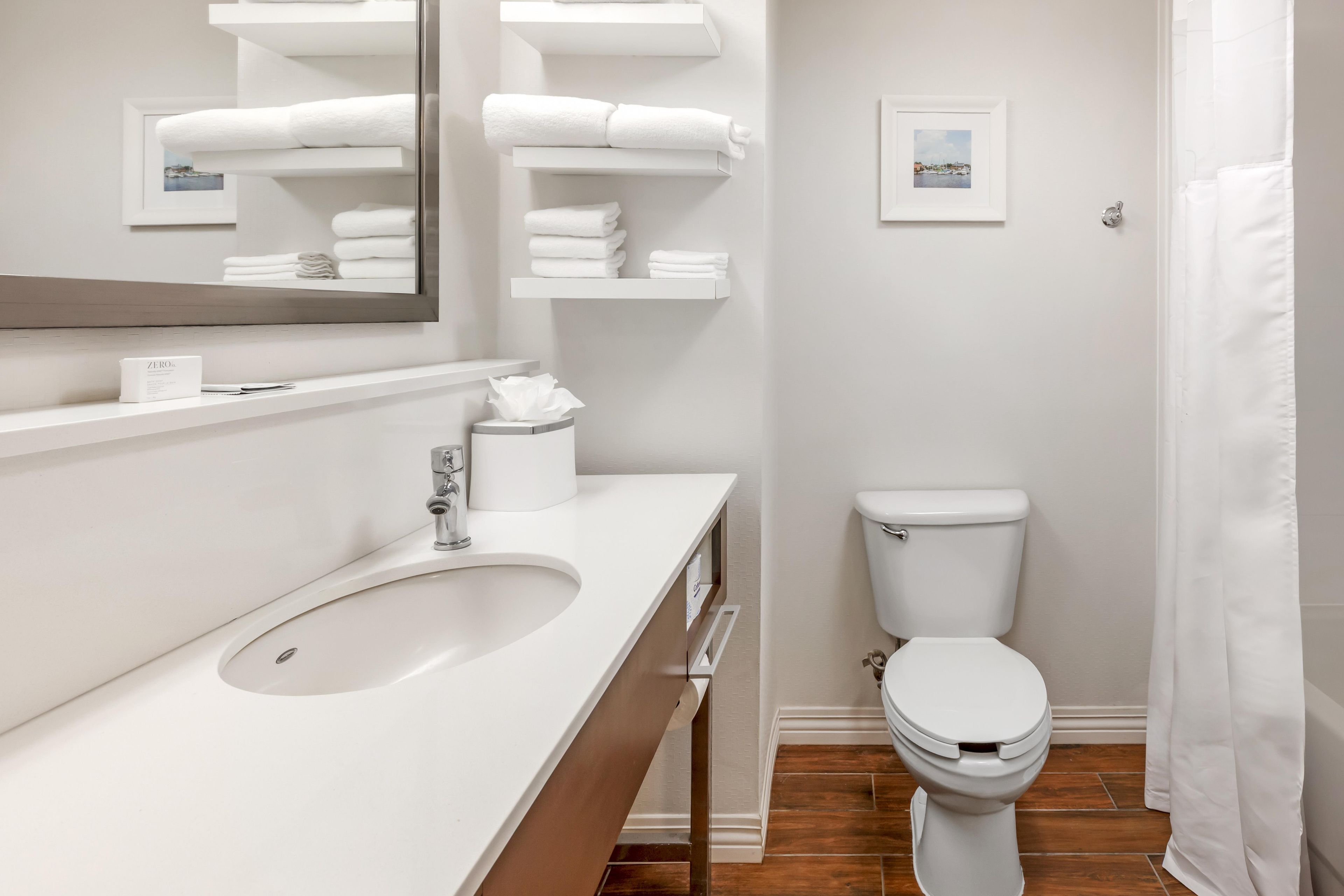 Ein modernes Badezimmer mit Waschbecken, Toilette und Duschvorhang.