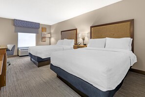 A hotel room with two beds, a desk, a chair, and a window with blinds. - Hampton Inn Washington (Washington)