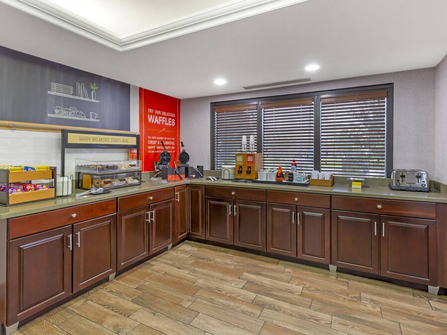 A breakfast area with a waffle station, a coffee machine, and a toaster.