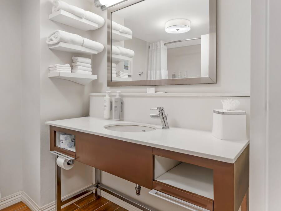Un baño moderno con un lavabo blanco, un espejo y un inodoro.