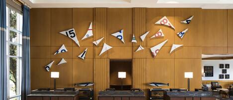 A lobby with a wooden ceiling, a reception desk, and a wall decorated with paper airplanes.