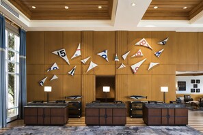 A lobby with a wooden ceiling, a reception desk, and a wall decorated with paper airplanes. - Hyatt Regency Chesapeake Bay (Cambridge)