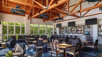 A spacious indoor area with high ceilings, wooden beams, and large windows allowing natural light.