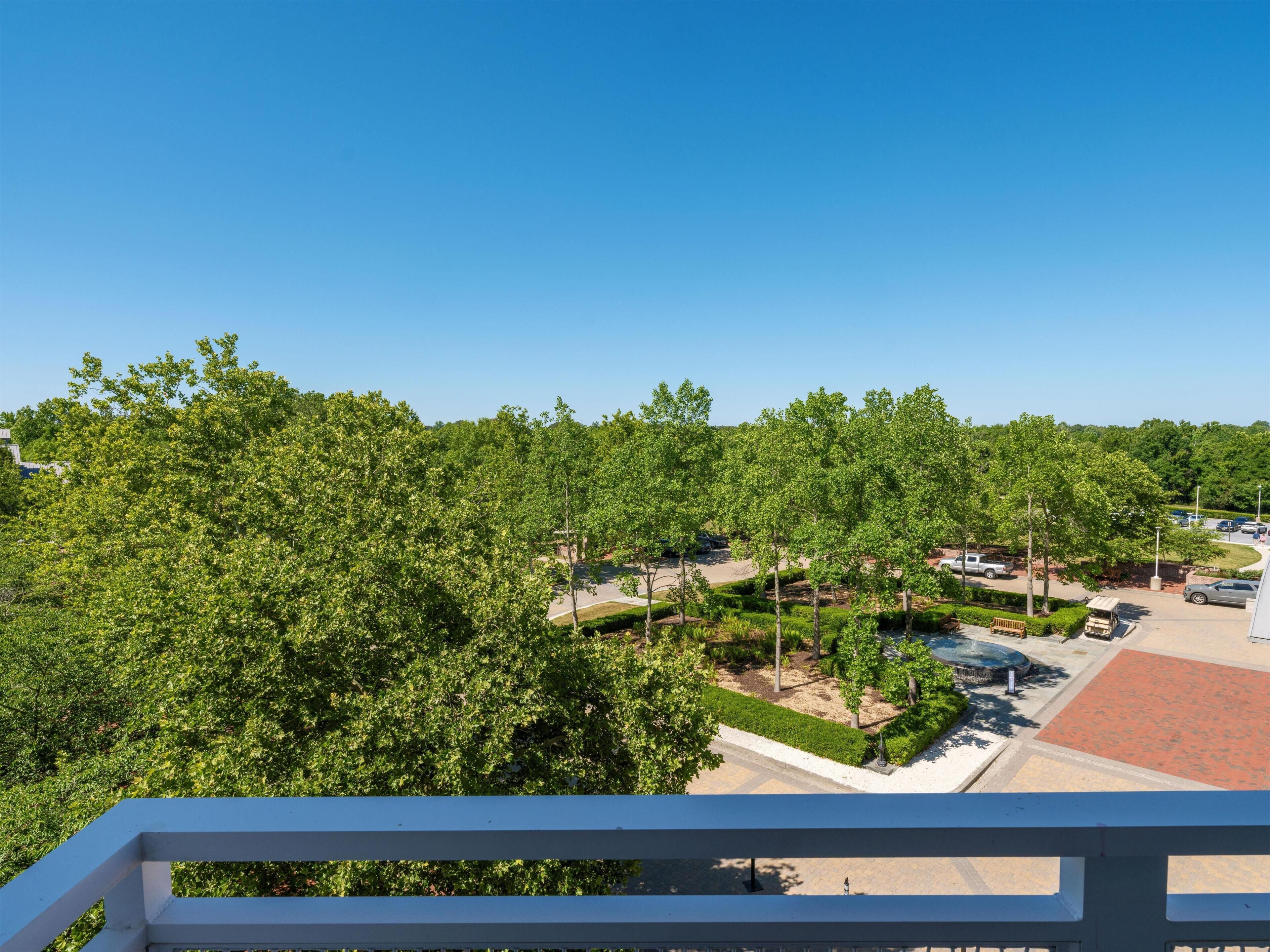A view of a parking area with trees and a clear sky.