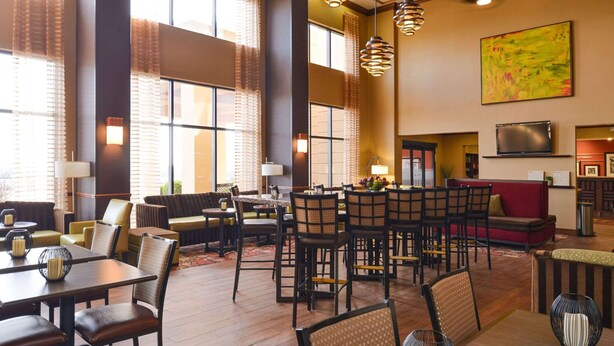A spacious hotel lobby with multiple seating areas, including a bar and a dining area. - Hampton Inn & Suites Springboro/Dayton Area South (Springboro)