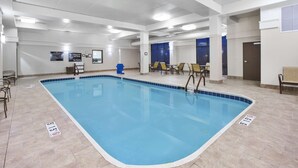 An indoor swimming pool with clear signage, a tiled floor, and a seating area with chairs and tables. - Hampton Inn & Suites Springboro/Dayton Area South (Springboro)