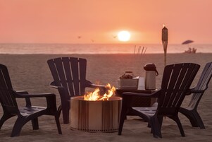 En la playa, sillas reclinables de playa, sombrillas, toallas de playa