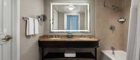 A modern bathroom with a double sink vanity, a bathtub, and a shower.