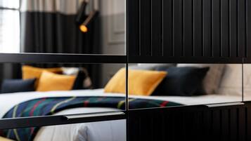 Une chambre d’hôtel moderne avec un lit, des oreillers et une fenêtre avec des rideaux.
