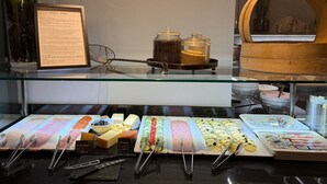 Mostrador de delicatessen con varios quesos, embutidos y productos preparados.