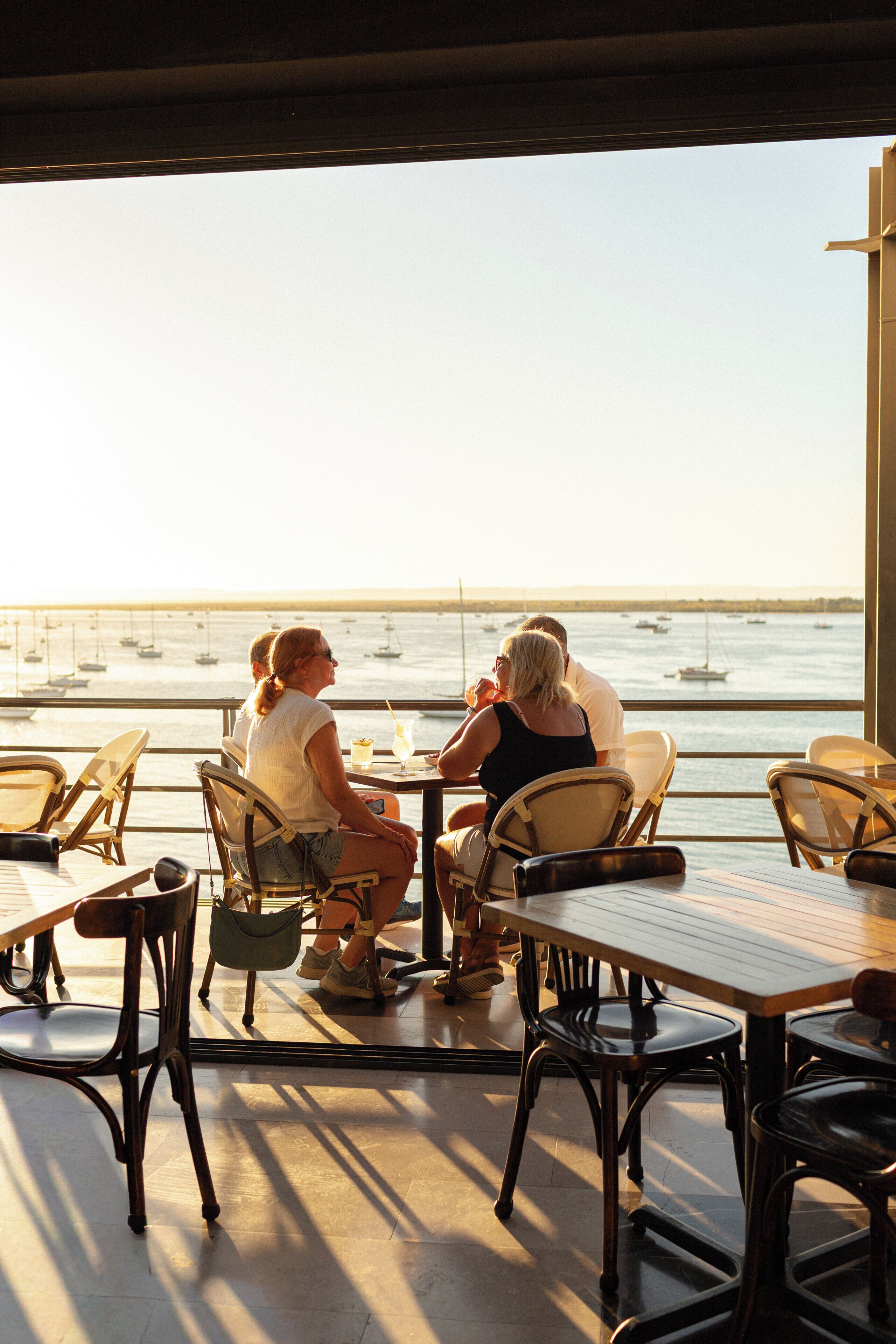 A restaurant with outdoor seating overlooking a marina.