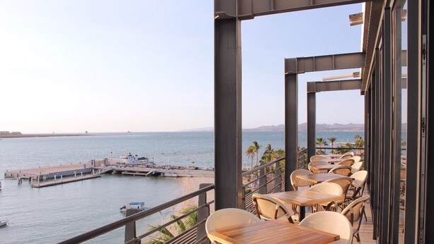 Balcón con mobiliario exterior que da a un puerto deportivo y al mar.