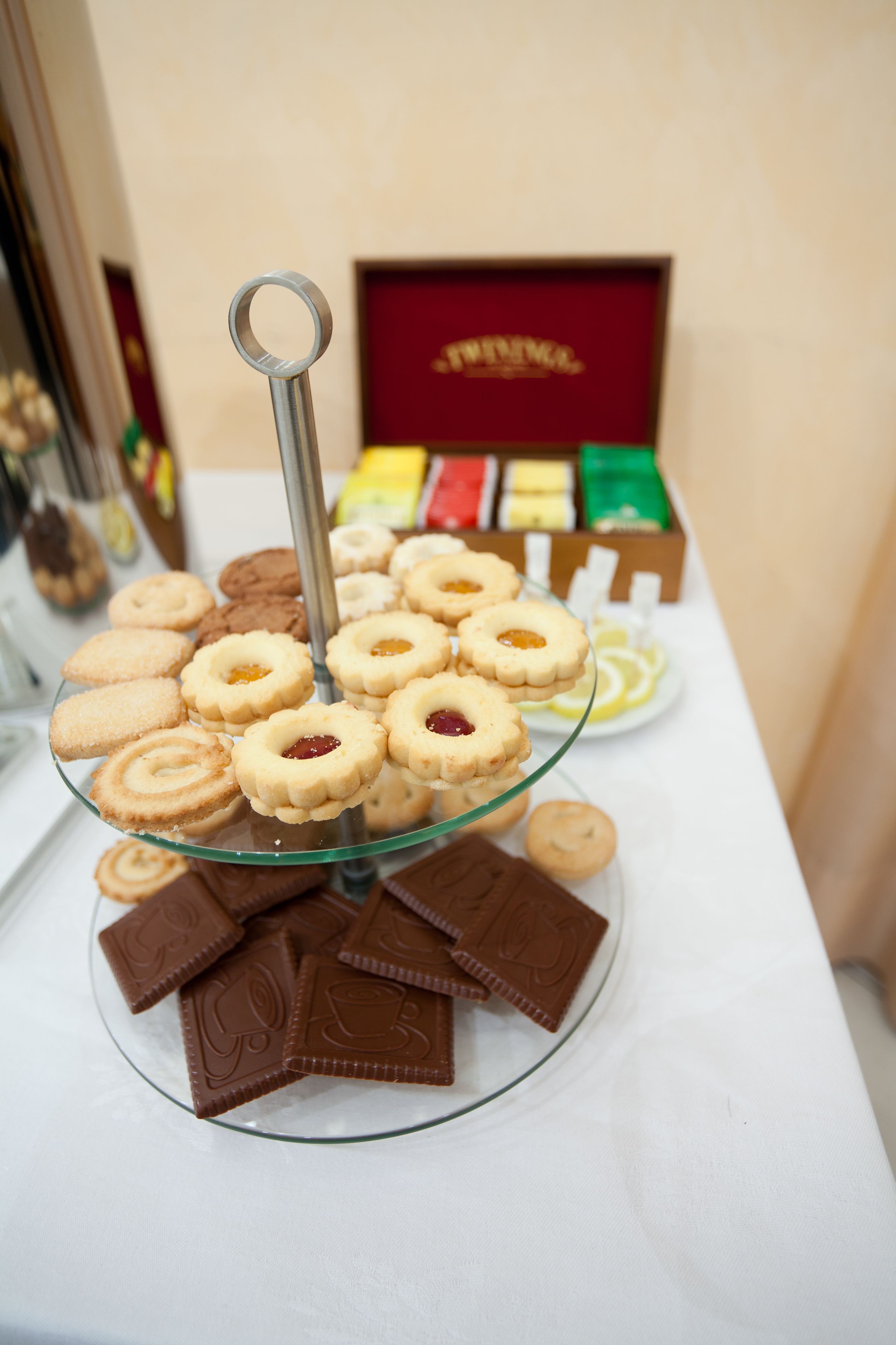 A glass display stand with assorted cookies and chocolate pieces.