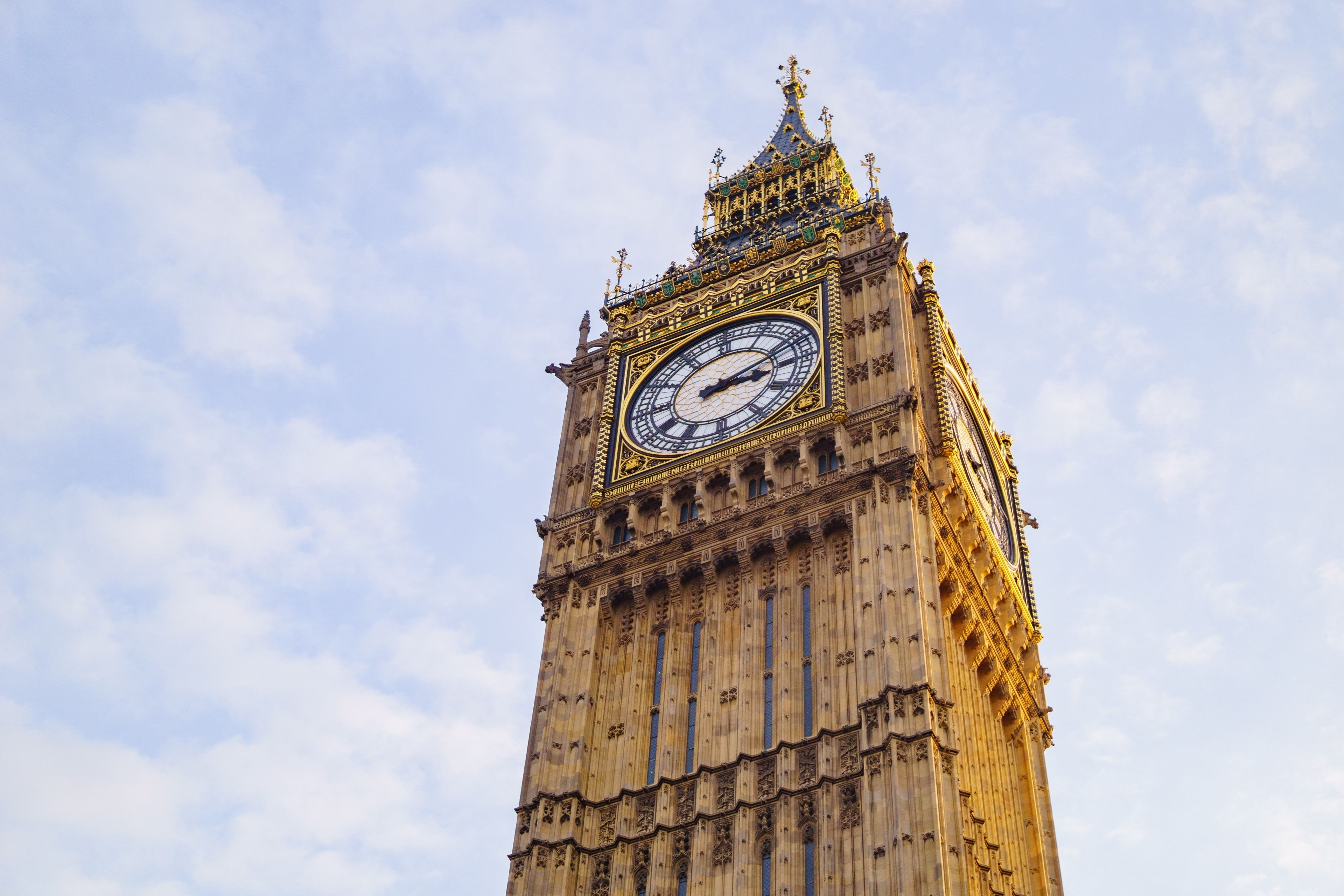 Un'alta torre dell'orologio con un grande quadrante e decorazioni elaborate.
