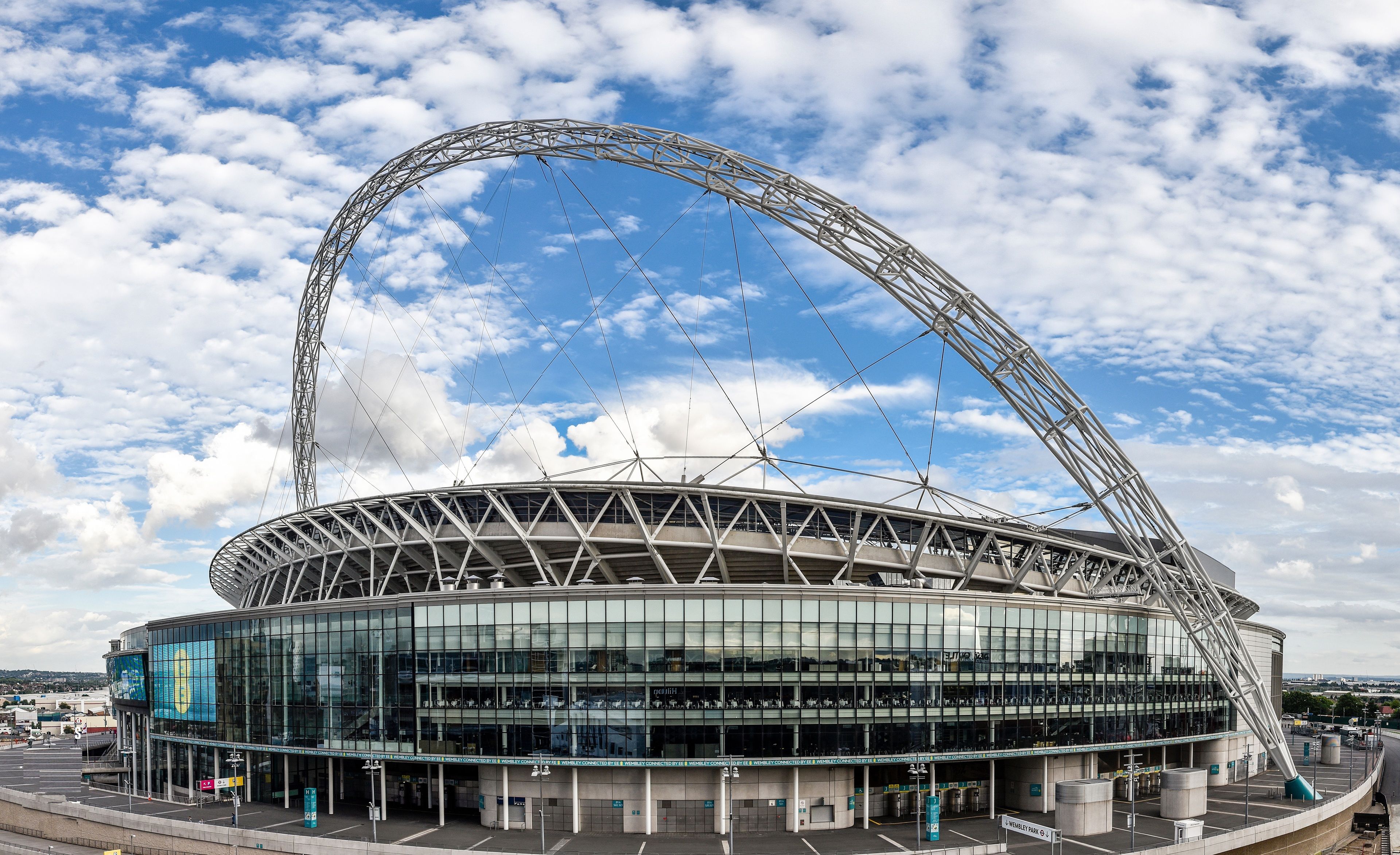 A stadium with a large, curved roof structure and a glass facade.