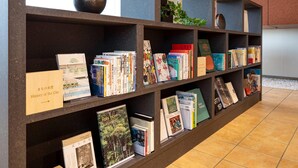 Una estantería con varios libros y un jarrón decorativo.