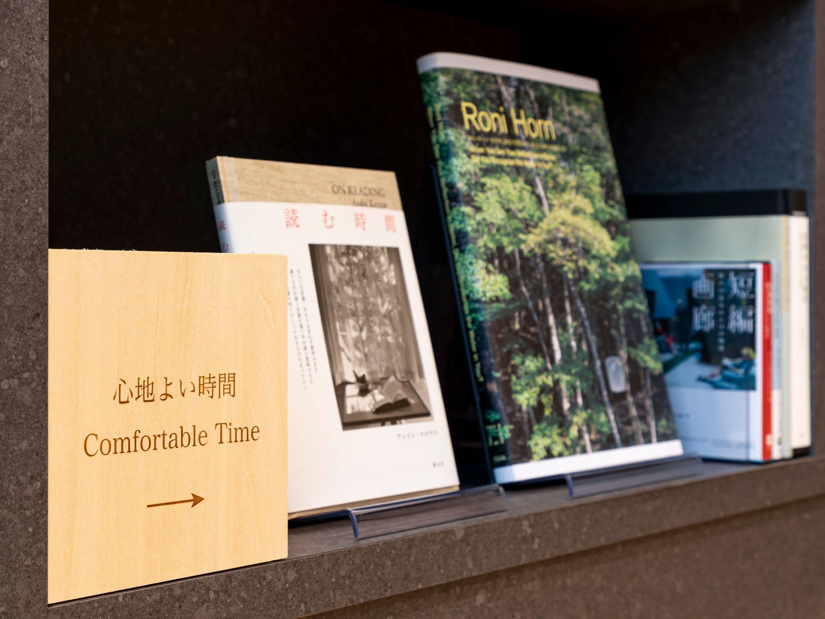 A bookshelf with books, including 'Roni Horn' and 'Comfortable Time'.