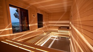 Una sala de sauna con paredes de madera y un banco.