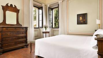 A bedroom with a large bed, a wooden dresser, a mirror, a window with curtains, and a painting on the wall.