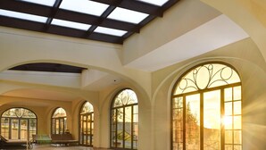 Una piscina interior con ventanas en arco y tragaluces.