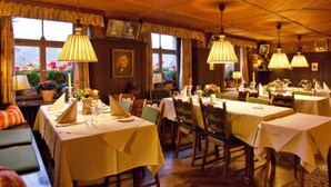 A cozy restaurant with wooden ceilings and tables set for dining. - Romantik Hotel Spielweg (Münstertal)