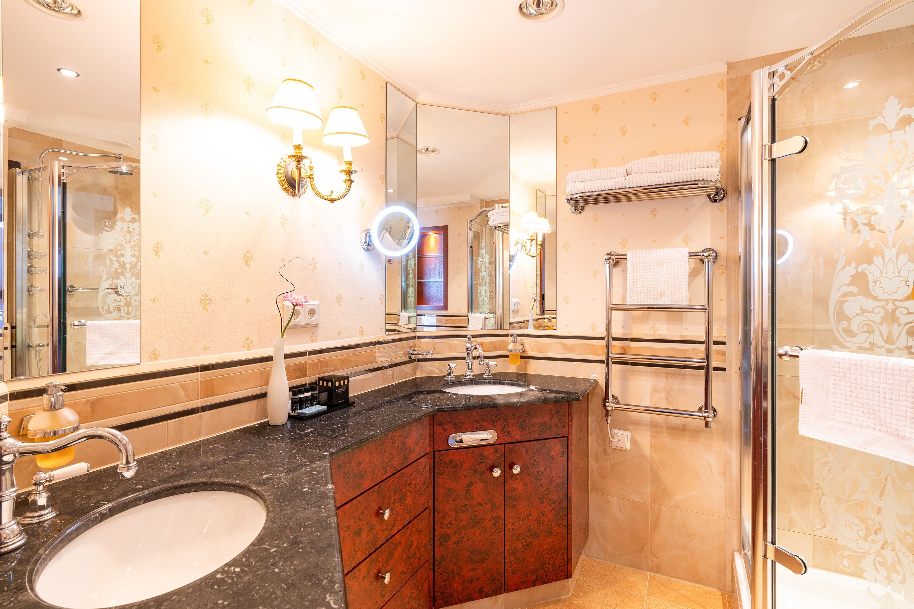 A bathroom with a large mirror, a sink, and a shower.