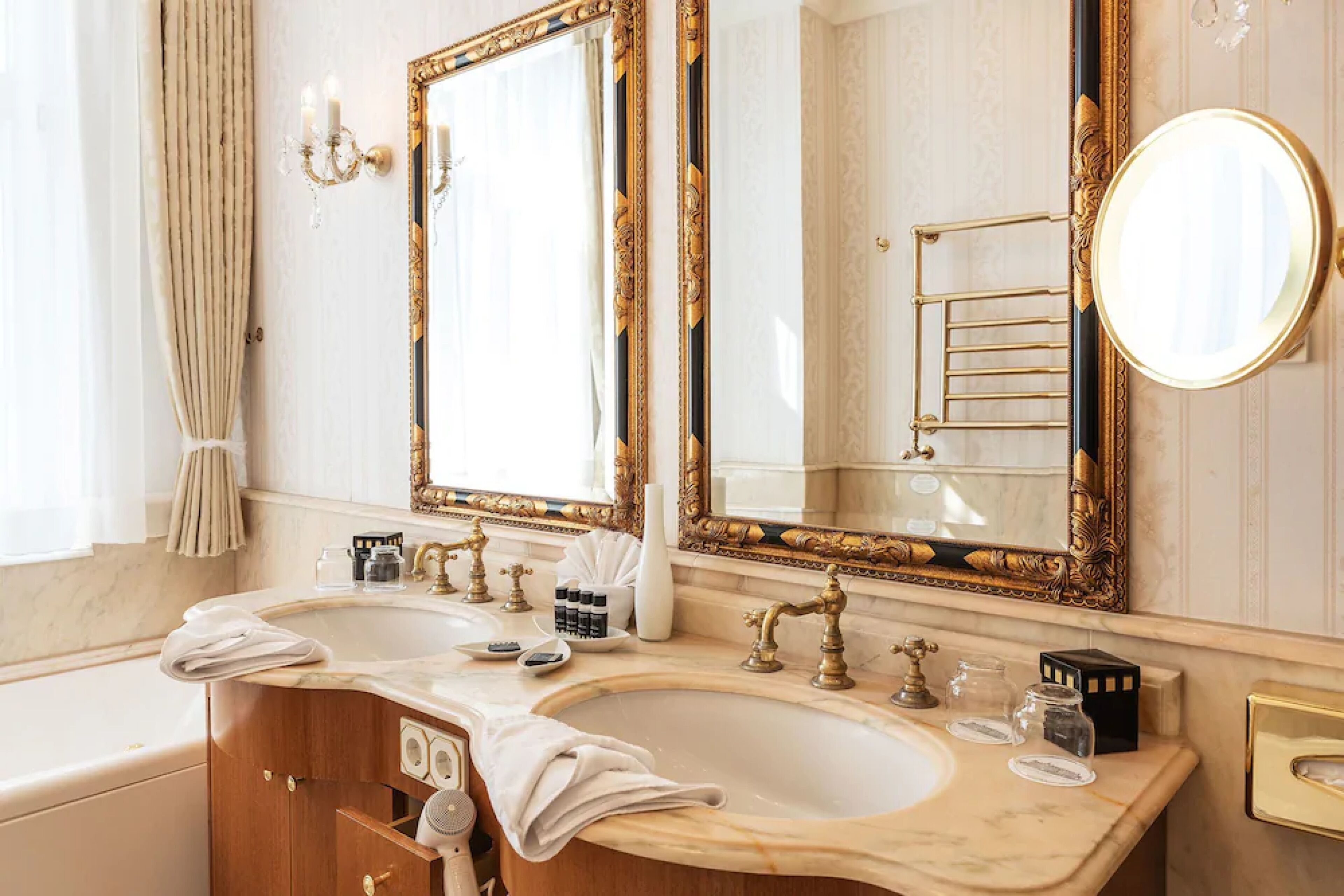 Une salle de bain luxueuse avec deux lavabos, un grand miroir et une baignoire.