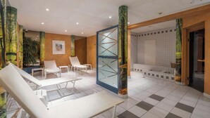Um hall de hotel moderno com poltronas brancas, um balcão de recepção e um amplo painel de vidro.