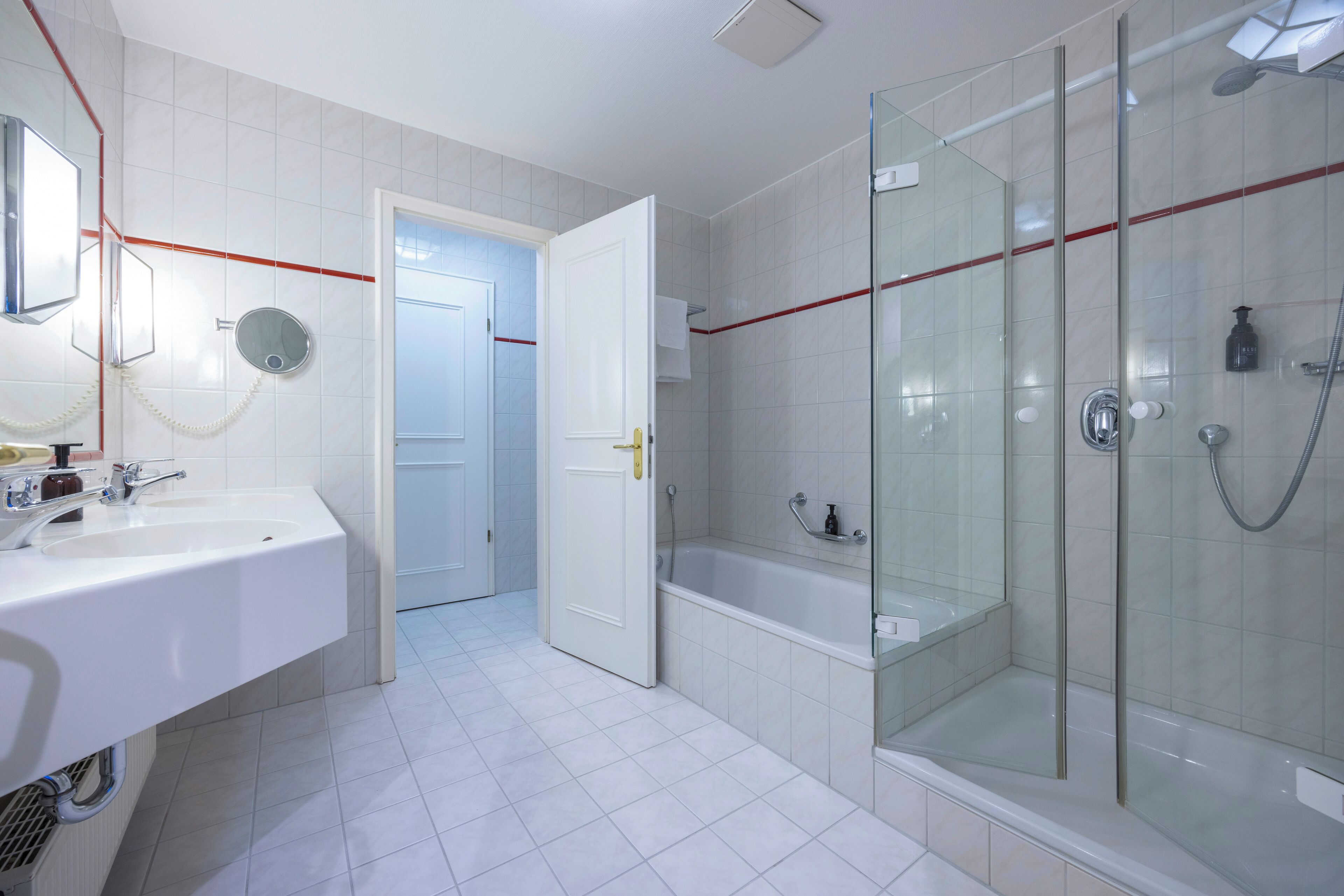 Un baño moderno con ducha envuelta en vidrio, bañera independiente y lavabo con espejo.