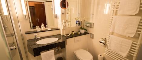 A modern bathroom with a sink, toilet, and a glass shower enclosure.