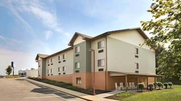 Hotel building with a flat roof and symmetrical facade, featuring brick and siding materials.
