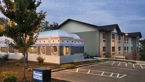 Un hotel con un edificio de cúpula distintiva, un estacionamiento y un letrero que indica un restaurante.