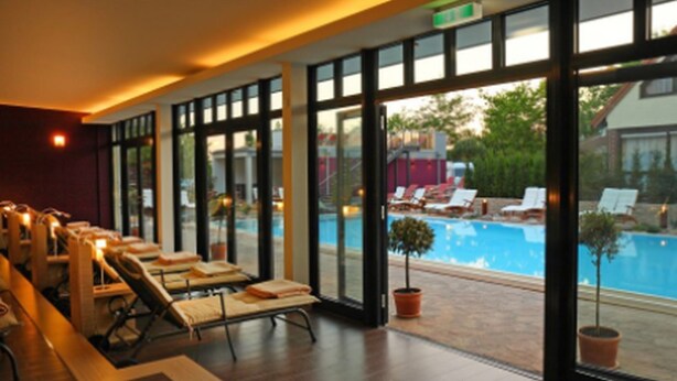 Un espace aménagé au bord de la piscine, avec des chaises longues et une vue sur la piscine.