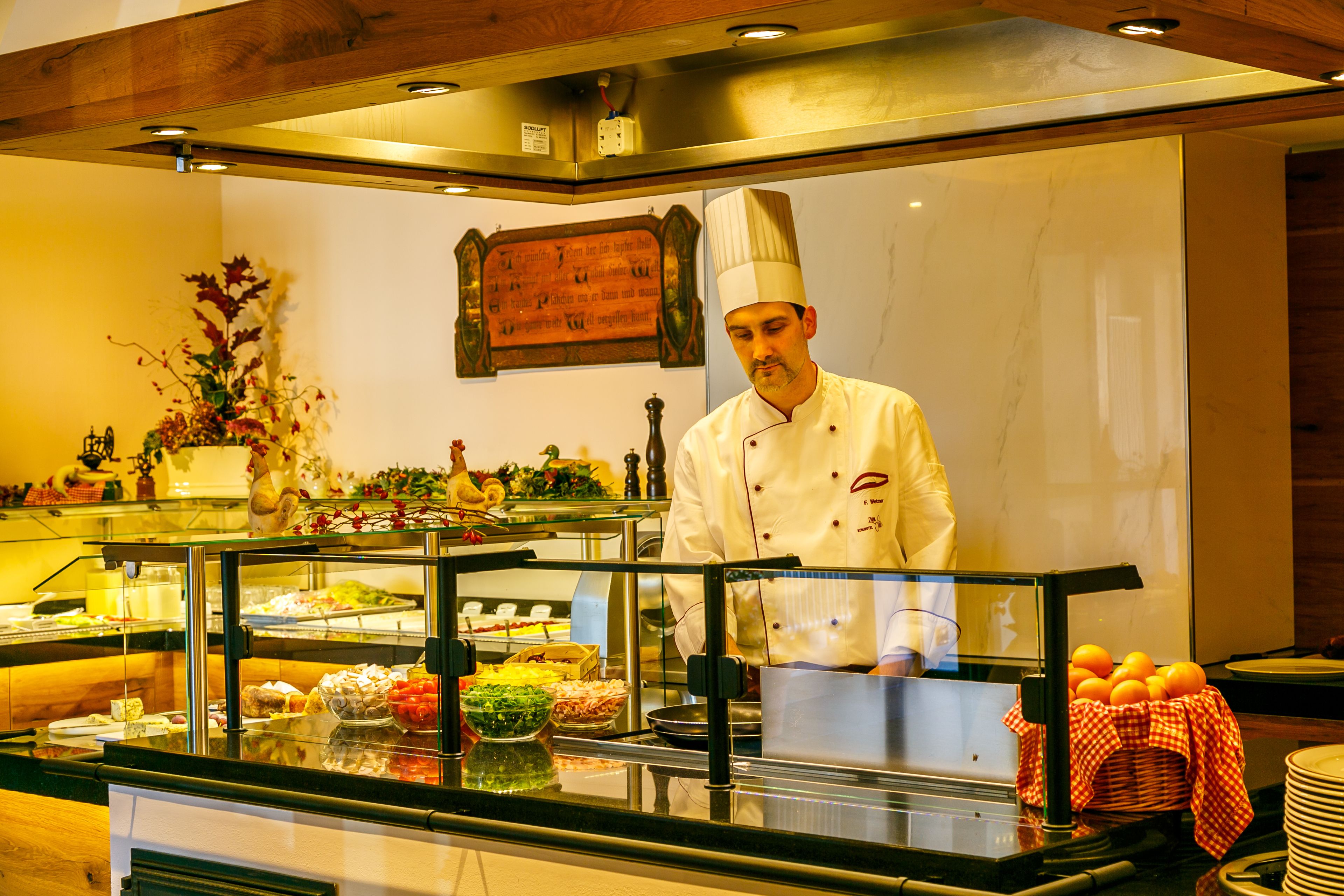 Ein Buffet mit verschiedenen Speisen und ein Koch in Uniform.