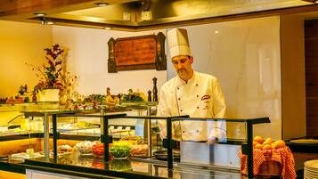 Ein Buffet mit verschiedenen Speisen und ein Koch in Uniform.