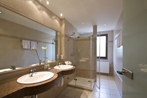 Habitación Deluxe doble | Baño | Ducha, artículos de higiene personal gratuitos y secador de pelo