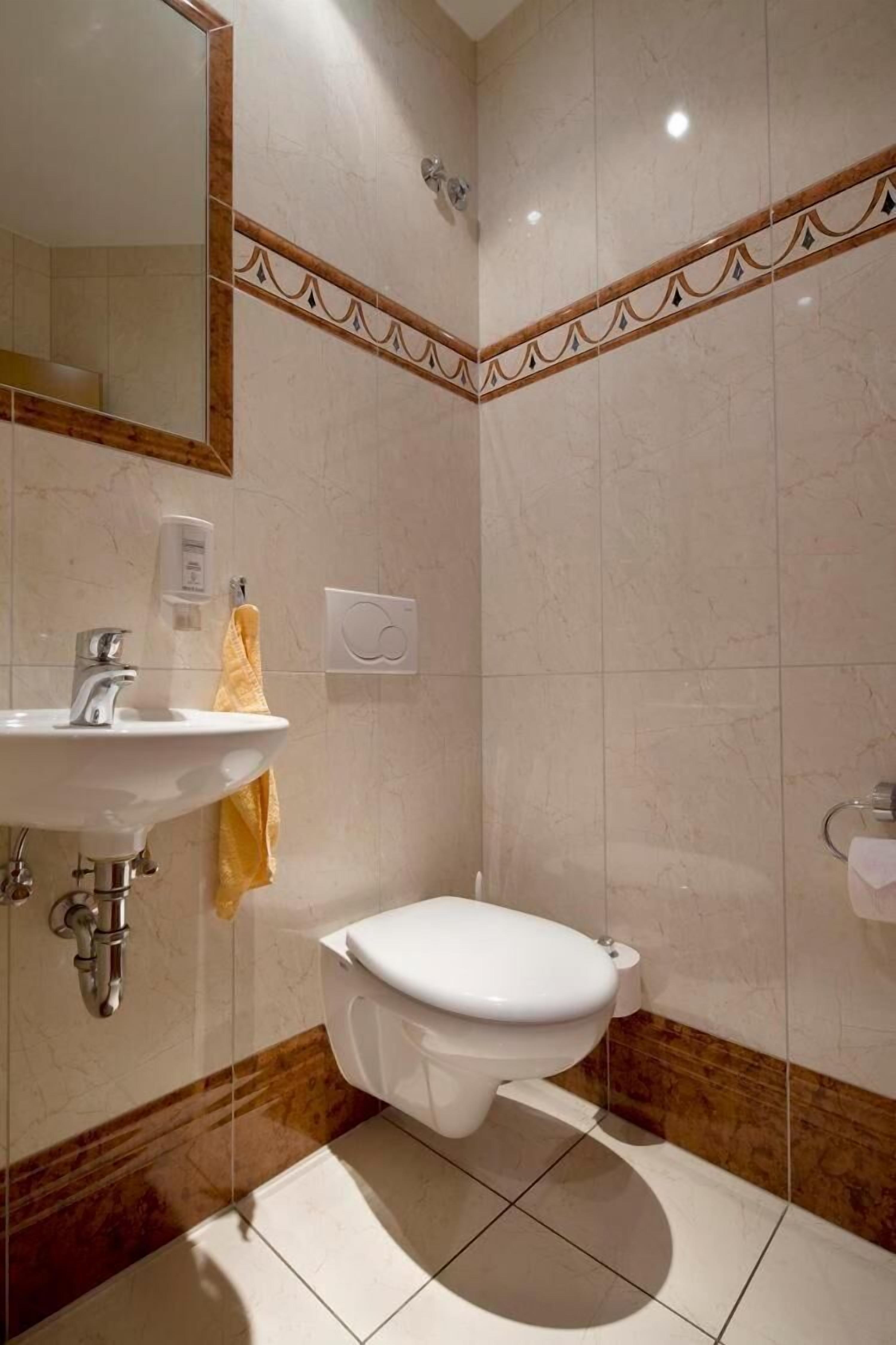 Un baño con lavamanos, inodoro y espejo.