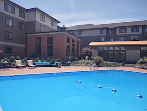 Una piscina al aire libre de temporada, sombrillas