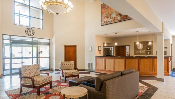 A hotel lobby with a reception desk, seating area, and a clock on the wall. - Comfort Inn & Suites South Burlington near University (South Burlington)