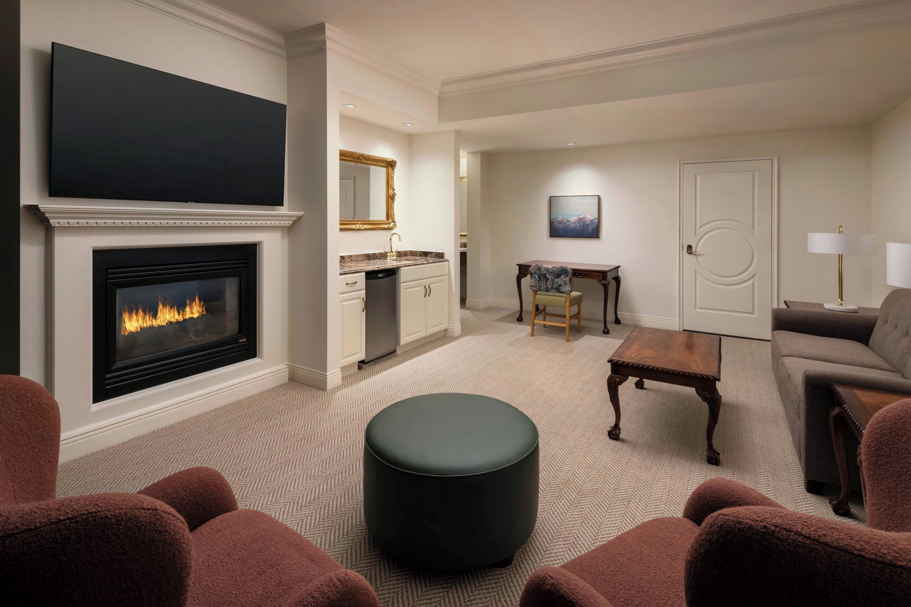 A living room with a fireplace, a television, a dining area, and a sofa.