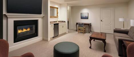 A living room with a fireplace, a television, a dining area, and a sofa.