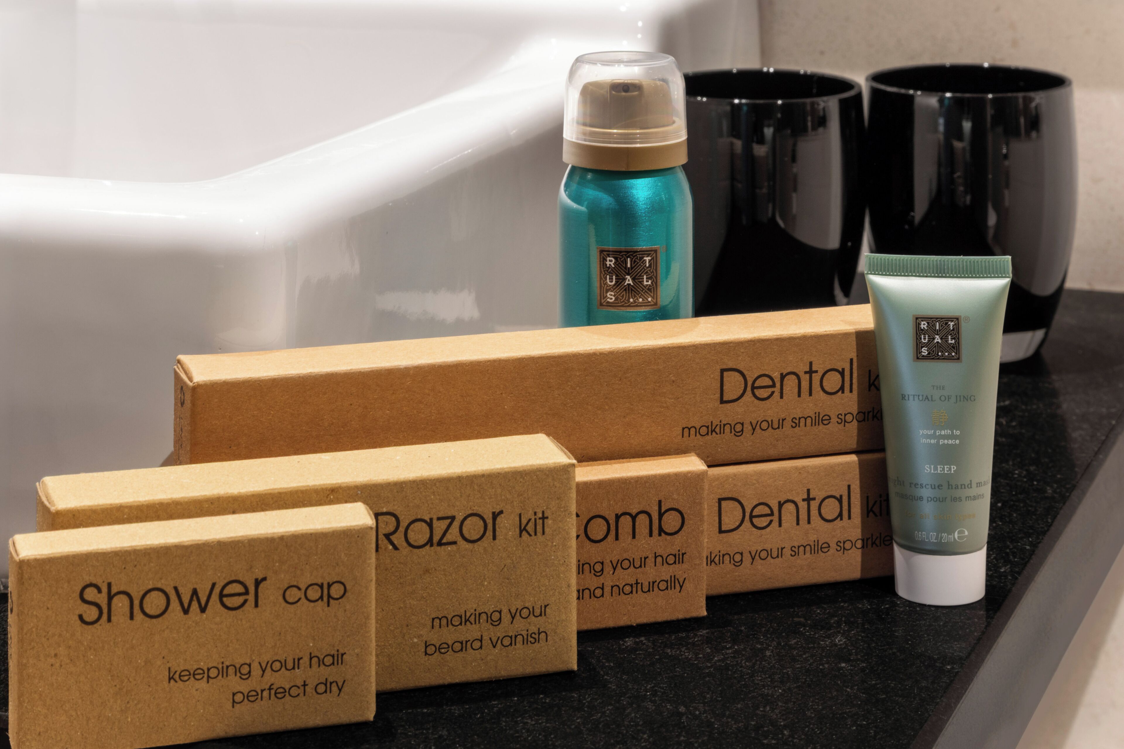 Un baño con una bañera, un portalapices para cepillos de dientes, un cepillo de dientes y un kit de afeitar.