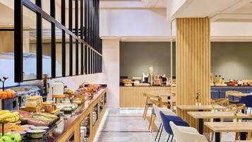 A buffet setup with various food items, wooden furniture, and a modern interior design.
