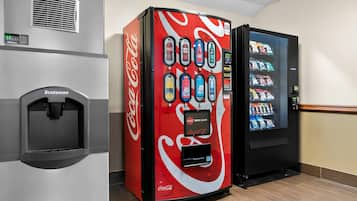 A vending machine with a Coca-Cola logo, a water dispenser, and a snack vending machine.