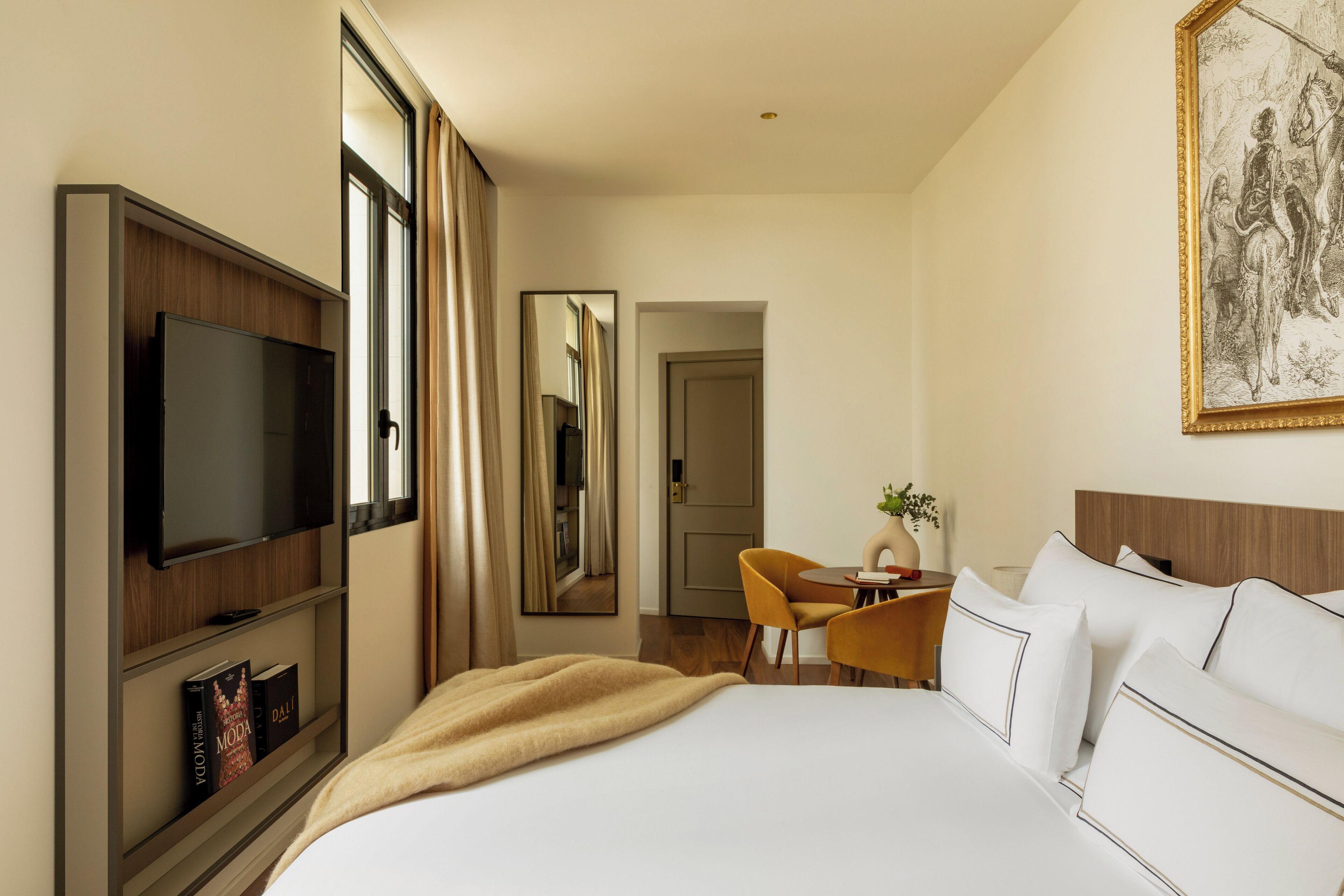 Een hotelkamer met een bed, een televisie, een bureau en een stoel.
