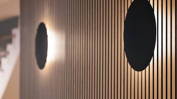 Un interior moderno con listones verticales de madera y formas circulares.