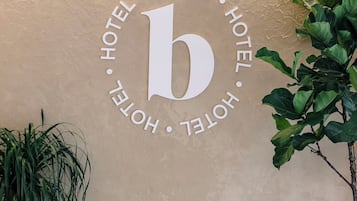 Een muur met een groot 'b' logo, omringd door herhaaldelijk het woord 'HOTEL'.