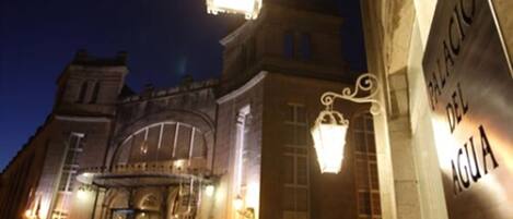 A historic building with a grand entrance, a sign reading "PALACIO DEL AGUA", and ornate lighting fixtures.