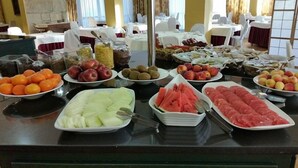 Ein reichhaltiges Buffet mit verschiedenen Früchten und Gemüsesorten, darunter Äpfel, Kiwis und Wassermelone.